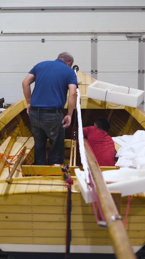 Vertical of Master working with new wooden homemade boat in workshop. Wide. Stock Footage 305517449