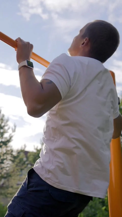Vertical of Mature man tries to do catch up on crossbar jumping in yard Stock Footage 275622236