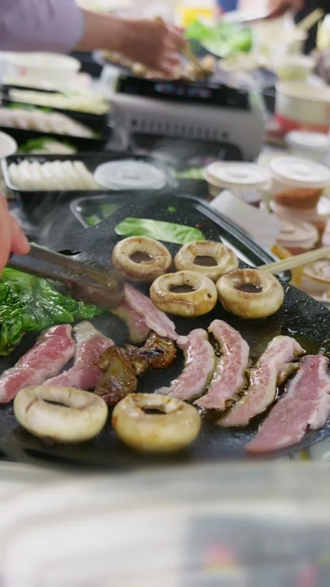 Vertical - Meat and vegetables grilled on an iron pan outdoors Stock Footage 330445598