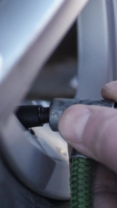 Vertical. Mechanic connects pump hose before starting process of tyre inflating Video stock 324201082