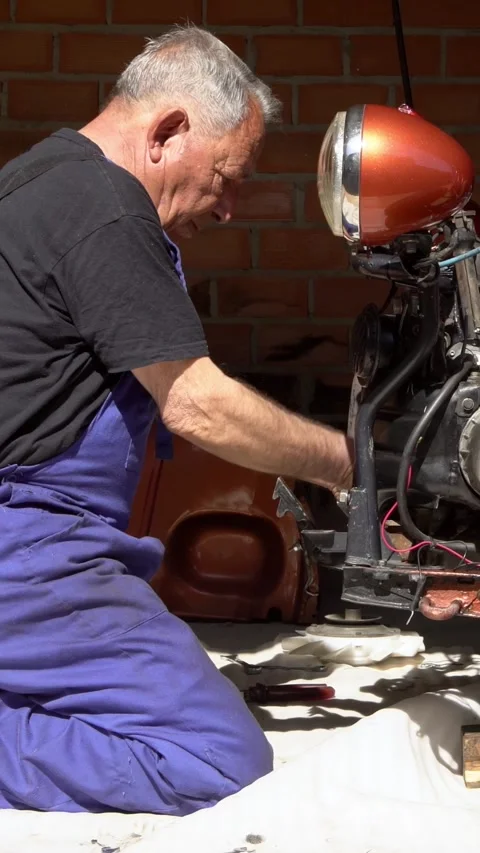 Vertical mechanic performing detailed maintenance on car engine in workshop Stock Footage 312025342