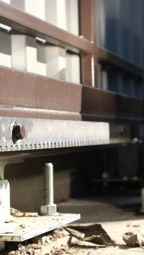 Vertical of mechanism of closing metal automatic gate. Moving gears driving gate Stock Footage 267733948