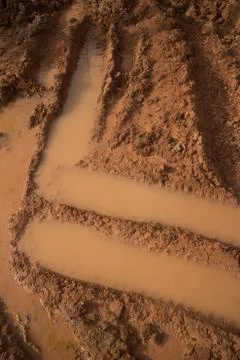 Vertical medium close up of angular tire tracks at muddy construction site Foto stock