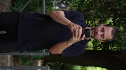 Vertical medium shot of 35-year-old man texting and smiling Stock Footage 277203784
