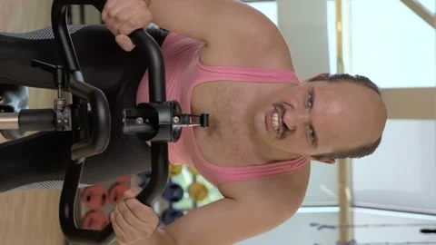 Vertical, medium shot, funny bald man is training hard on a stationary bike Stock Footage 132324208