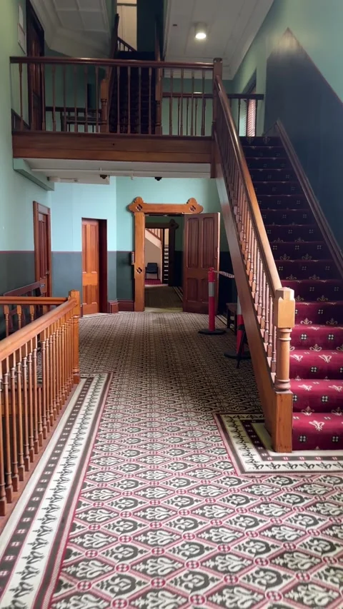 Vertical Medium Shot of Historic Interior Corridor with Patterned Carpet Stock Footage 345801376