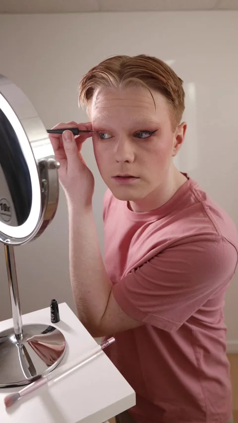 A Vertical Medium Shot of A Man Applying Eyeliner in Front of Mirror Stock Footage 310218909