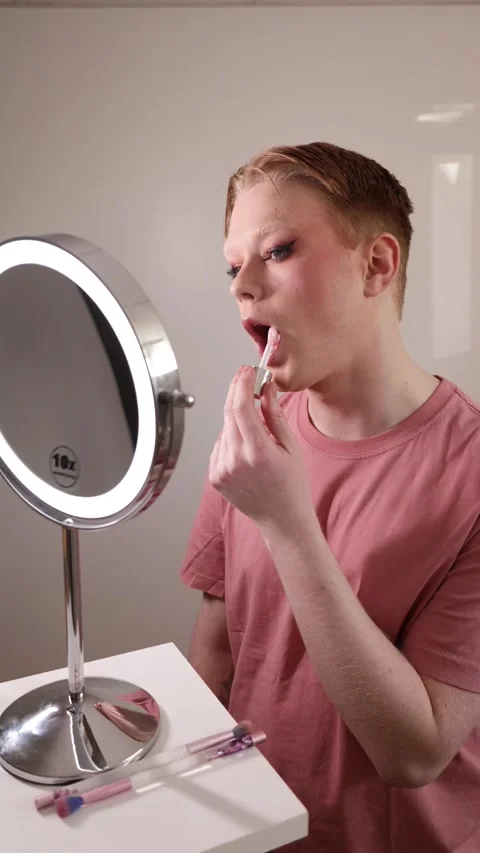A Vertical Medium Shot of a Man Applying Lip Gloss in Front of Mirror Stock Footage 310222539