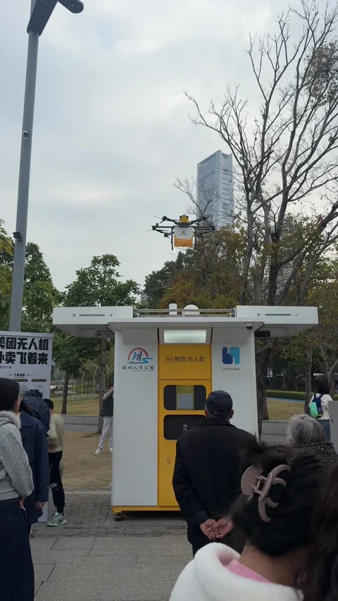 Vertical Medium Shot of a Meituan Delivery Drone Landing on an Automated Kiosk Stock Footage 345349135