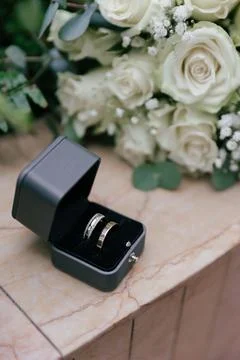 Vertical medium shot of two gold wedding rings inside an open dark velvet box Stock Photos