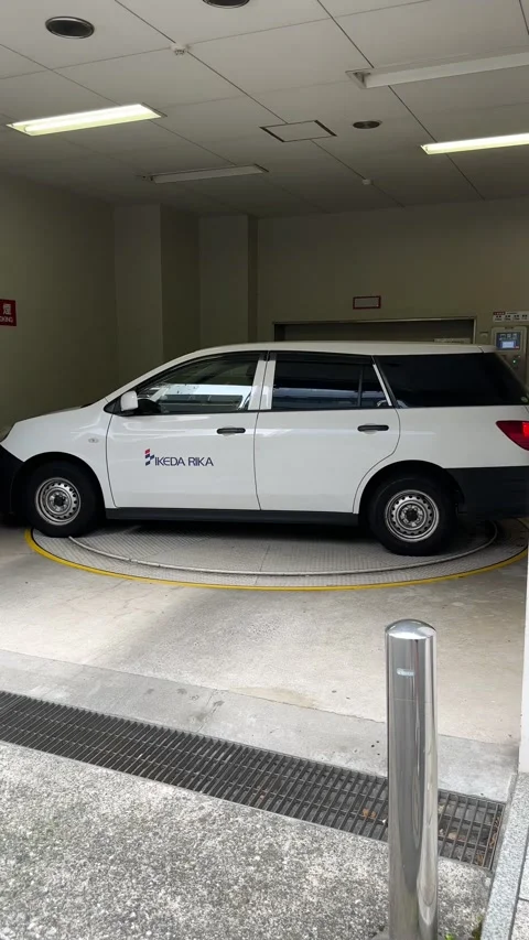 Vertical Medium Shot of White Car Parked on Indoor Turntable Inside Japanese Vidéo 346176521