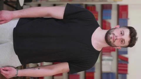 Vertical medium shot of young man looking serious at camera Stock Footage 277295397