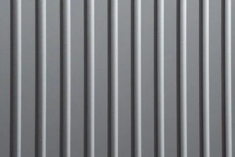 Vertical metal bars create a simple and modern pattern in a light gray color on Stock Photos
