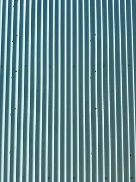 A vertical metal sheet shows lines and small marks on its surface. The sheet  Foto stock