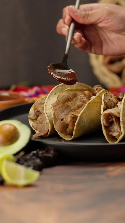 Vertical mexican video, pouring red sauce on some Mexican tacos Stock Footage 282423388