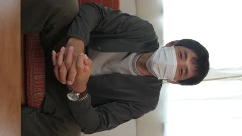 Vertical : Middle aged asian man with face mask on talking to the camera. 25P. Stock Footage 224897687