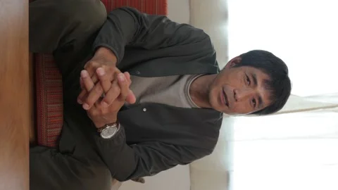 Vertical : Middle aged asian man talking to the camera. 25P. Stock Footage 224897858