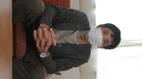 Vertical : Middle aged asian man with face mask on talking to the camera. Stock Footage 224901930