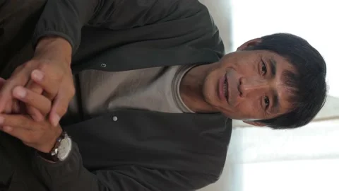Vertical : Middle aged asian man talking to the camera. Stock Footage 224902452