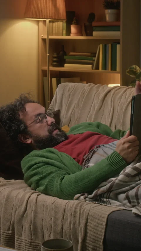 Vertical of Middle-aged Man Lying down Using Tablet Computer at Night Vídeo Stock 341677254