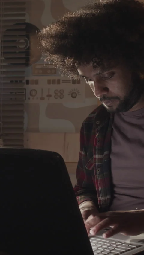 Vertical of Middle Eastern Nerd with Messy Hair Typing on Old Laptop Stock Footage 276415755