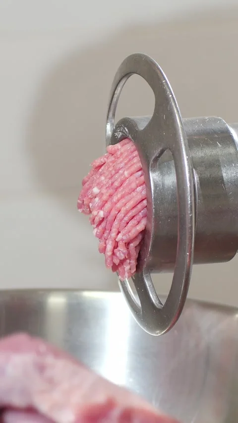 Vertical. Minced meat obtained from pieces of meat in an electric meat grinder. Video stock 323465139