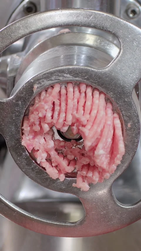 Vertical. Minced meat slowly comes out of meat grinder and falls into plate Video stock 323465179