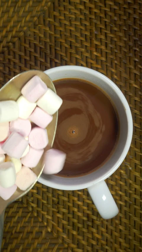 Vertical - Mini marshmallows added to a cup of cocoa, hot chocolate or coffee. Stock Footage 301786250