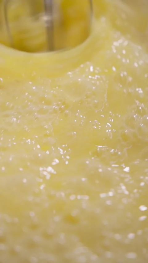 Vertical. Mixer whips egg mixture into bubbly foam creating texture for baked Stock Footage 324195789