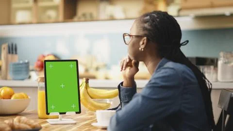 Vertical mockup green screen on tablet in kitchen at wooden table Stock Photos