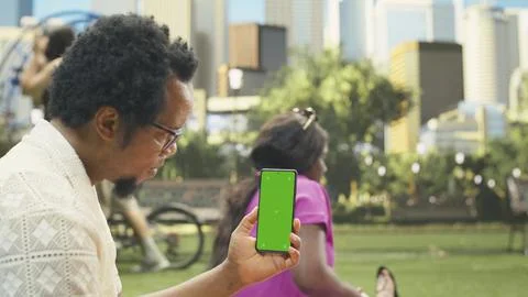 Vertical mockup screen replacement on mobile phone dominates picnic scene Stock Photos