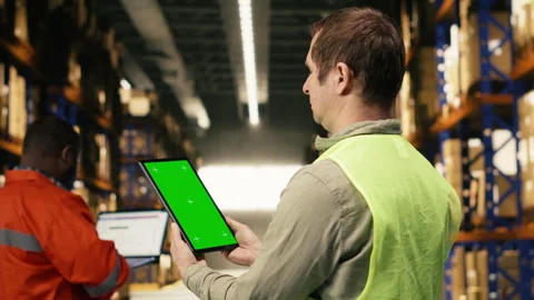 Vertical mockup screen on tablet near warehouse staff in logistics hub Stock Footage 332909850
