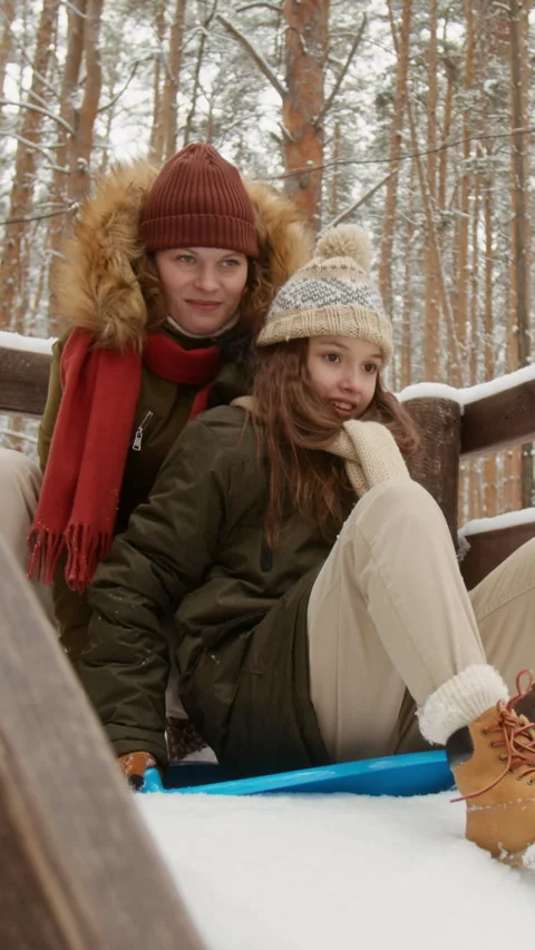 Vertical of Mother and Daughter Preparing for Sledding in Snowy Forest 스톡 동영상 341855048