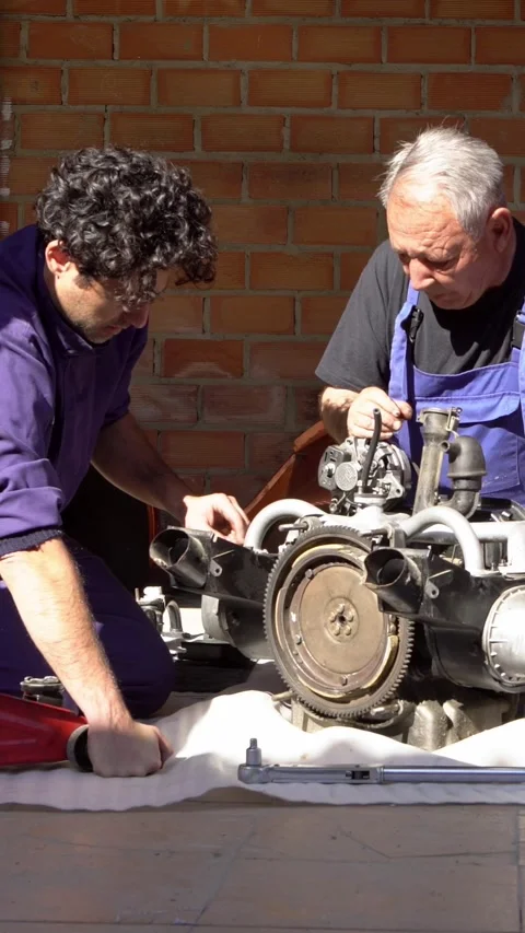 Vertical Motor components being fixed with care by a mechanic in bright sunlight Stock Footage 309240066
