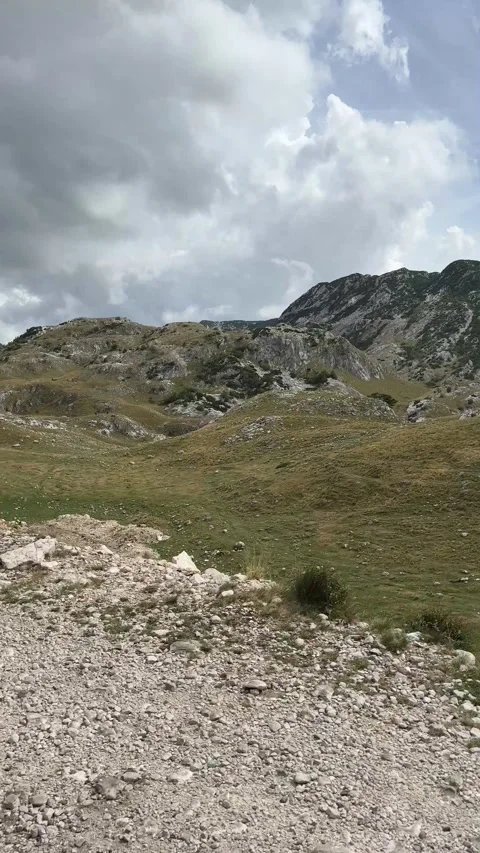 Vertical mountain cliffs and grassy slopes in Montenegro summer scene Stock Footage 319450179