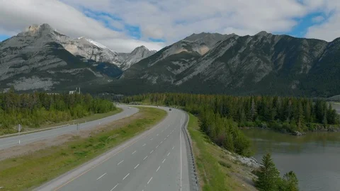 Vertical move over highway leading toward postcard rocky mountain backdrop Video stock 113011208