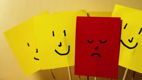 Vertical movement of red paper with sad depressed face next to happy yellow.. Video stock 291647485