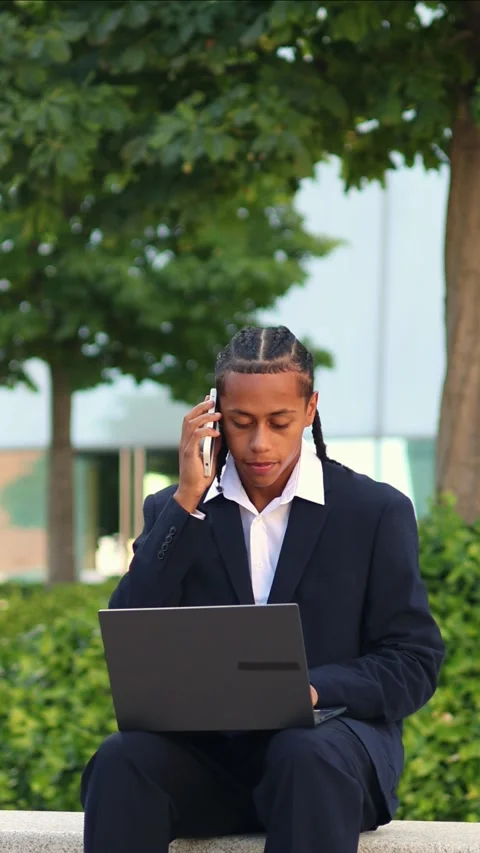 Vertical multicultural Businessman working on laptop and talking on phone o.. Stock Footage 317014407