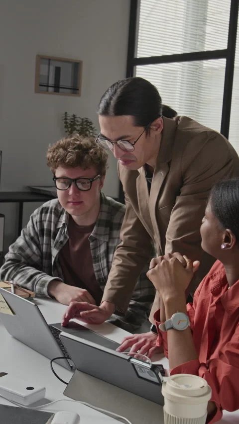 Vertical of Multiethnic Tech Team Discussing Software Project on Laptop Stock Footage 336718802