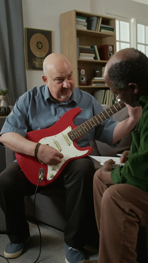 Vertical of Music Teacher Explaining Electric Guitar to Senior Student Stock Footage 333424043