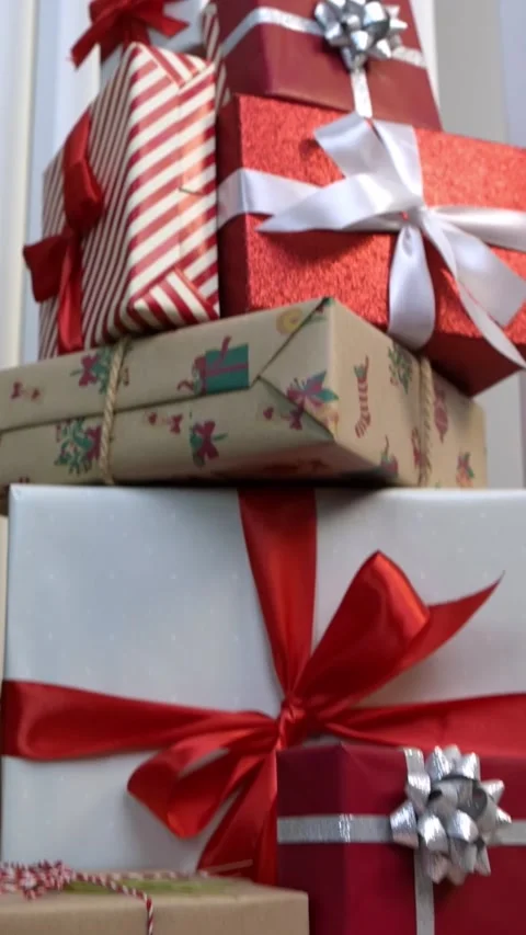 Vertical Neatly wrapped gift boxes beneath contemporary Christmas tree in a home Stock Footage 317110580