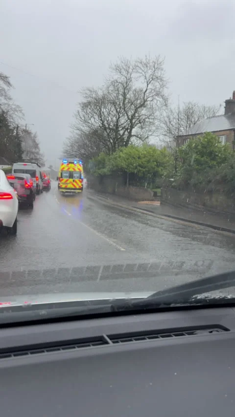Vertical. NHS ambulance van with emergency blue lights rushing past traffic. Stock-Footage 331534383