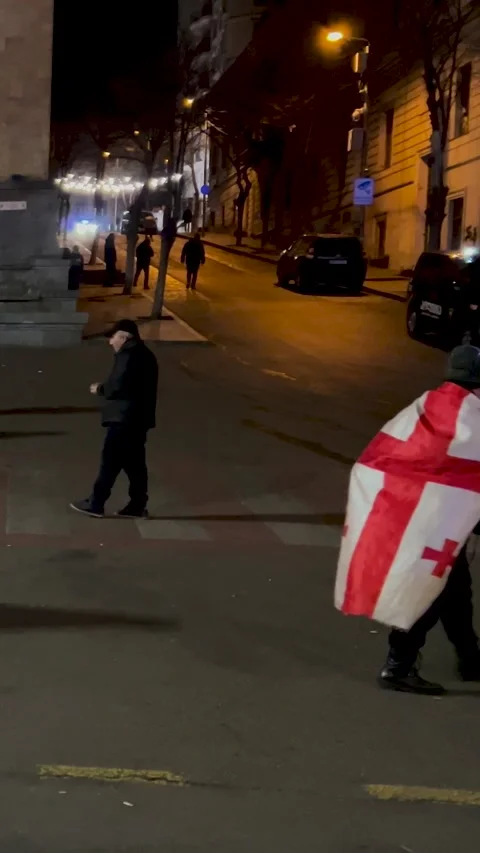 Vertical night video. Back view. Man in cloak. Georgian flag with cross Stock Footage 296253426