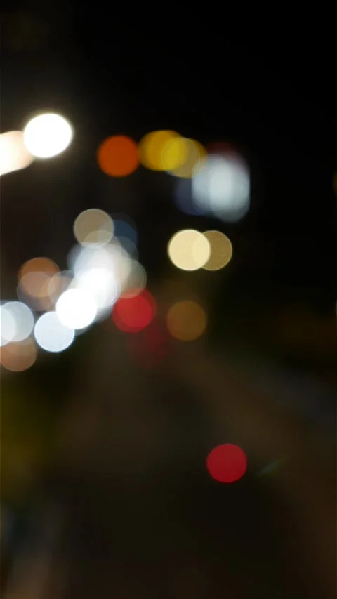 Vertical night view with defocused car headlights and urban street lights formin Stock Footage 337994149