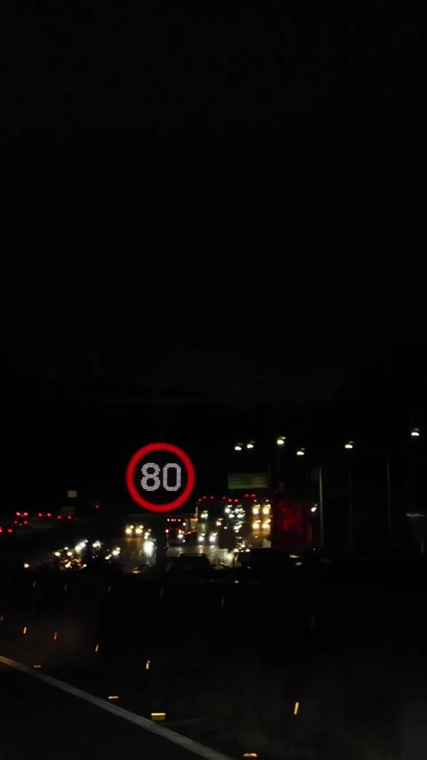 Vertical Nighttime View of Highway Speed Limit Sign and Traffic Vidéo 329460527