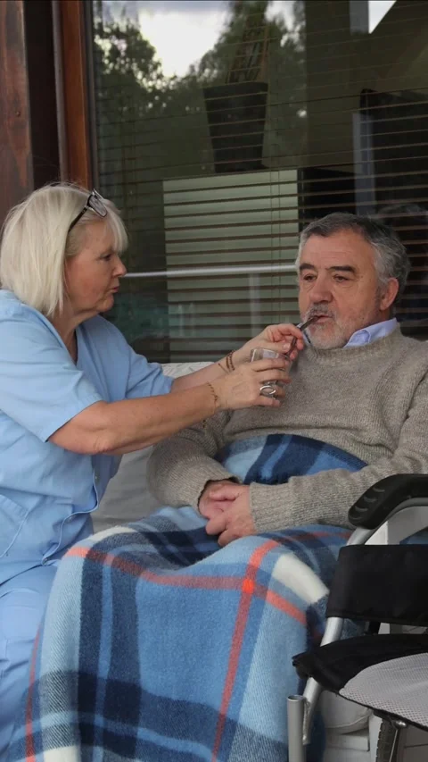 Vertical Nurse assisting elderly man drinking water from glass Stock Footage 300172214