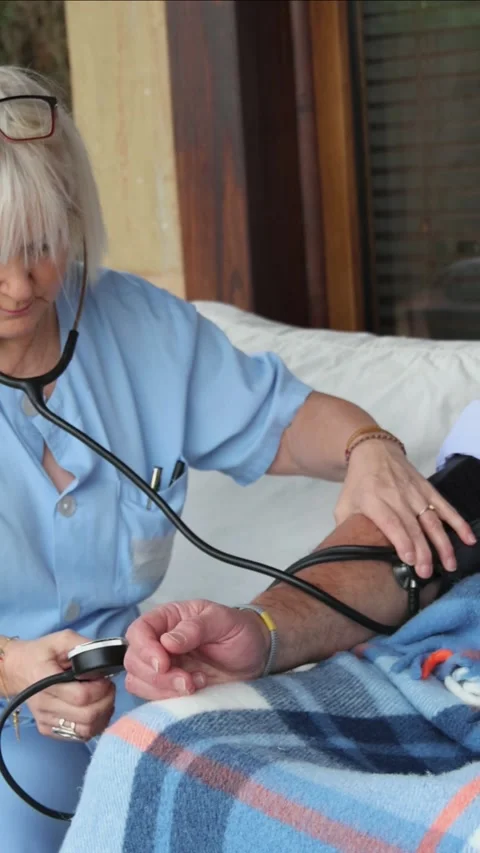Vertical Nurse checking blood pressure of elderly patient Stock Footage 300172219