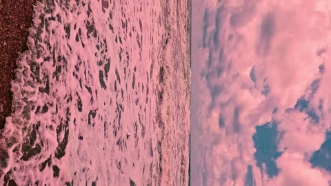 Vertical. Ocean Waves Falling Slowly on Sandy Beach at Sunset Pink Puffy Clouds  Stock Footage 297674452
