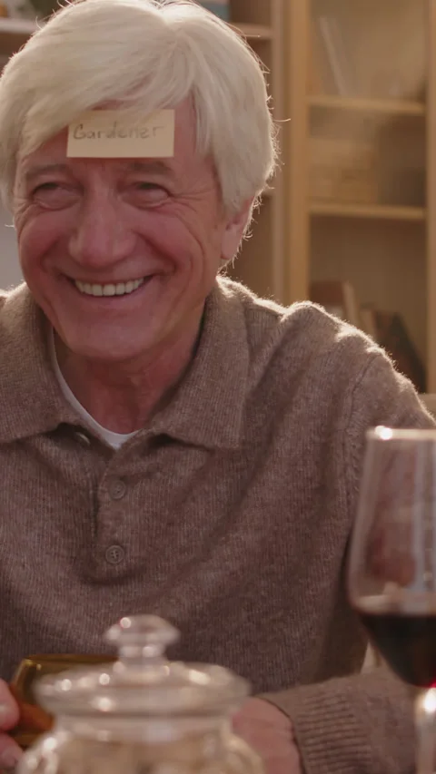 Vertical of Old Man Playing Guessing Game with Friends at Home Vidéo 272297670