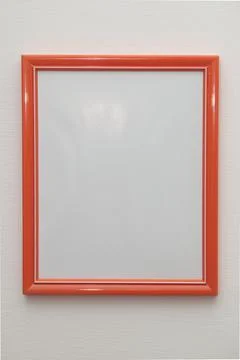 Vertical orange plastic frame on indoor white wall Stock Photos